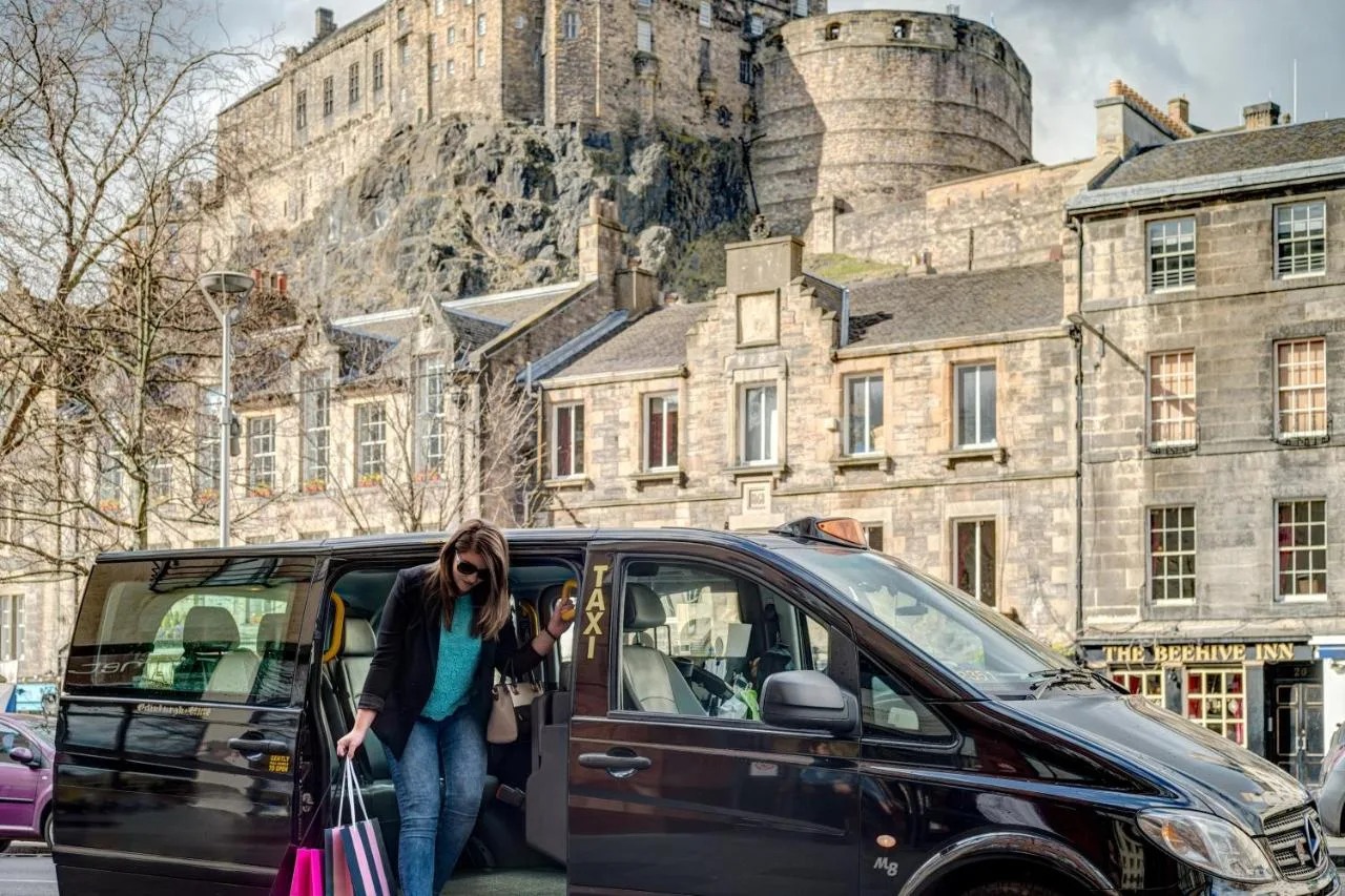 a woman is getting out of a black van at Apex Grassmarket Hotel in Edinburgh