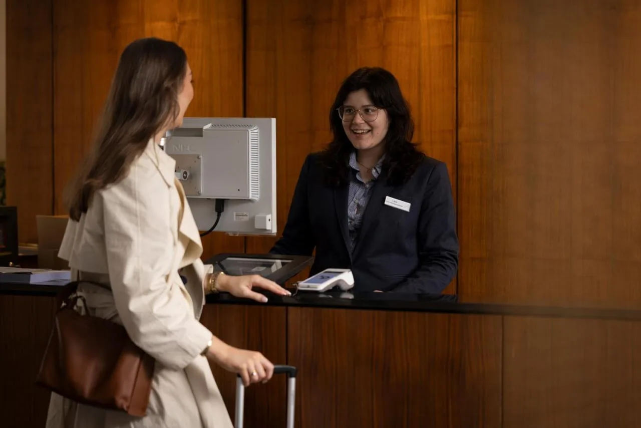 a woman standing at a counter talking to a woman at Apex Grassmarket Hotel in Edinburgh