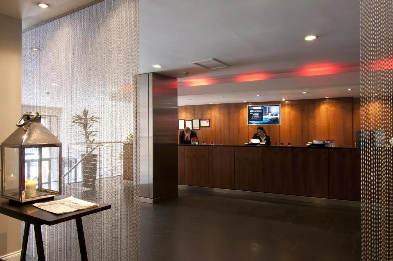 a lobby of a hotel with a reception desk at Apex Grassmarket Hotel in Edinburgh