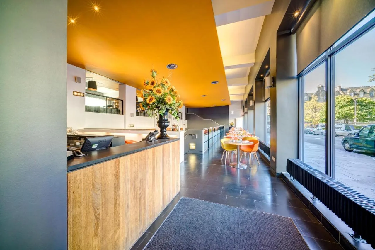 a kitchen with a counter with a vase of flowers at Apex Grassmarket Hotel in Edinburgh